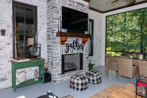 Screened-in back porch with outdoor fire place and outdoor TV