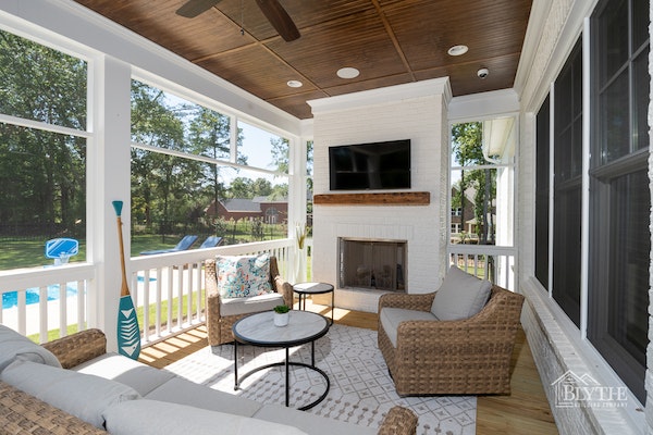 Beadboard ceiling on screened-in back porch with tv and outdoor fireplace