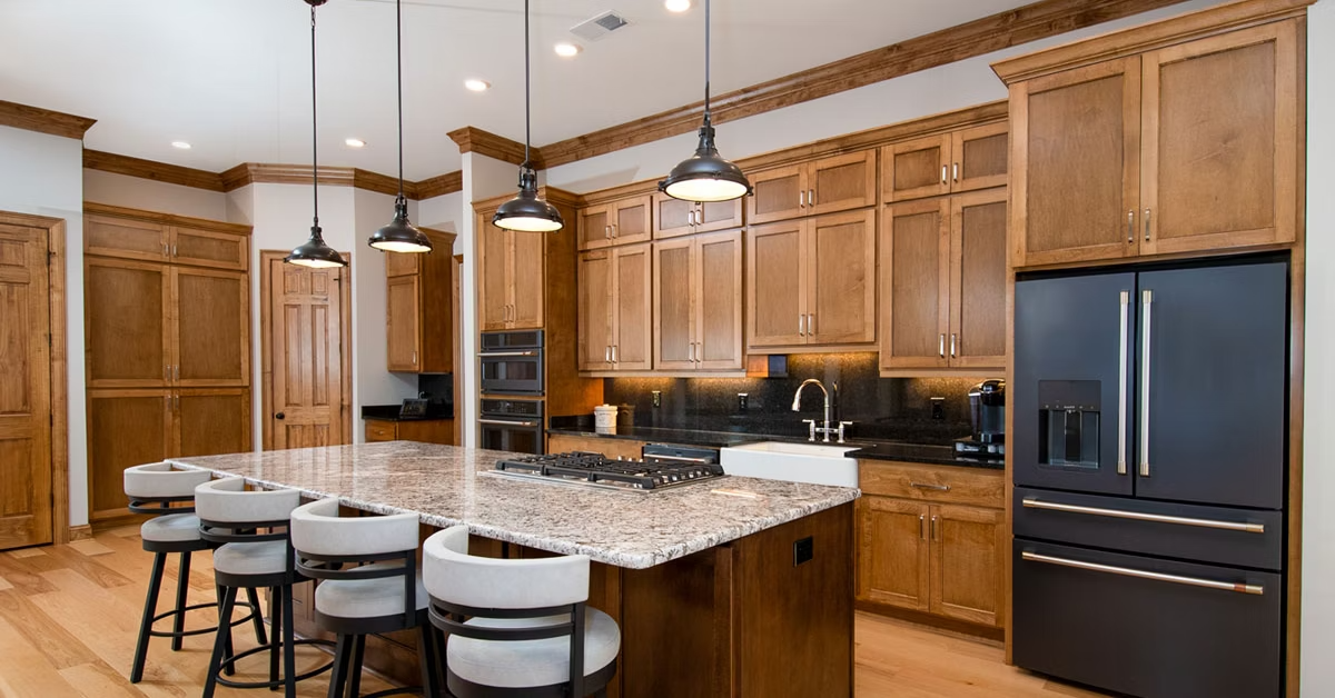 Stained maple wood cabinets and hickory wide planked floors in a luxury kitchen