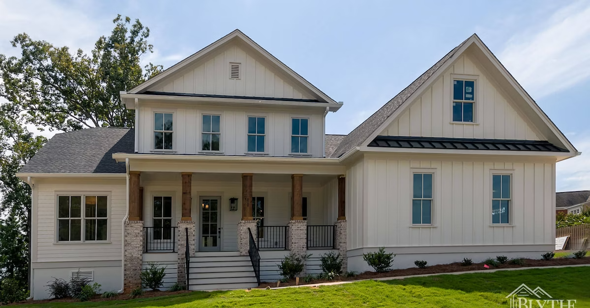 Modern Craftsman 2-story home with board and batten, metal roof accent over the garage, and large front porch with lime-washed brick and stained wood columns.
