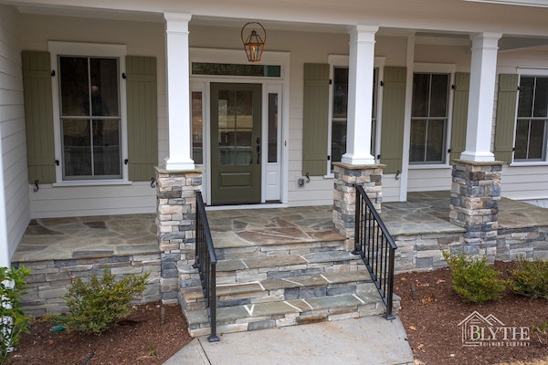 Front Porch With Half Stacked Stone Columns and Green Board and Batten Shutters