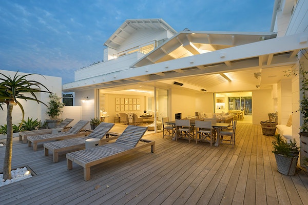 Pressure-treated wood luxury deck with modern home at twilight