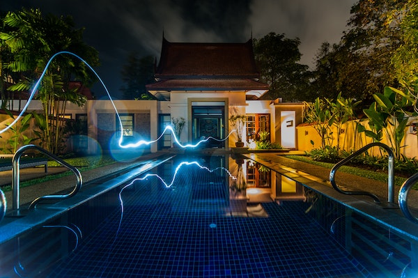 Luxury-home-at-night-with-pool-and-glowing-line-of-electricity-going-to-house.jpg