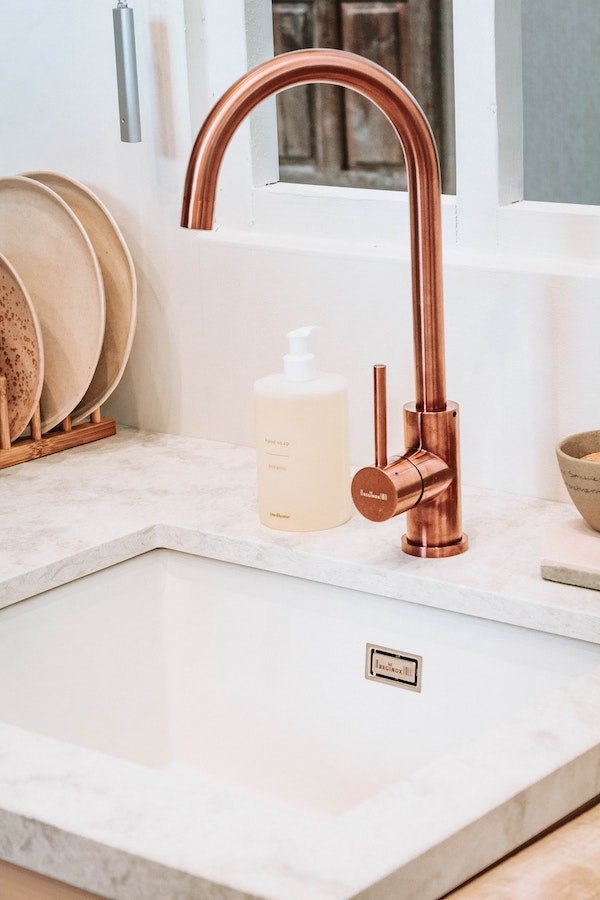copper-faucet-in-kitchen-with-undermounted-sink-and-handsoap-container