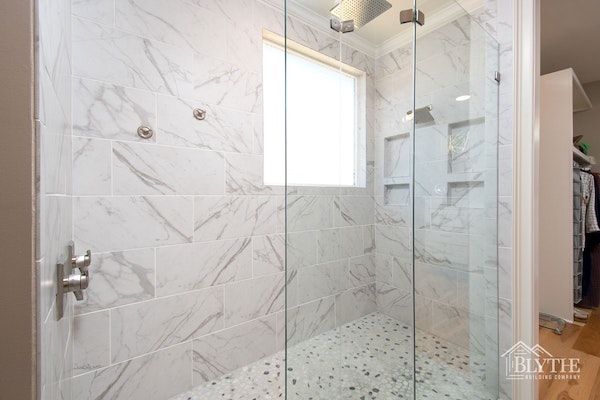 Oversized Shower with marble tile In Luxury Master Bathroom With Tile Walls And Tile Mosaic Floor And Two Shower Heads 1