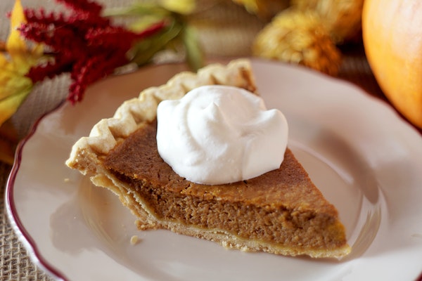 pumpkin-pie-slice-with-cool-whip-on-fine-china-plate