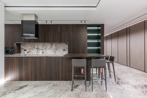Contemporary kitchen with marble backsplash, marble floors, and dark cabinets