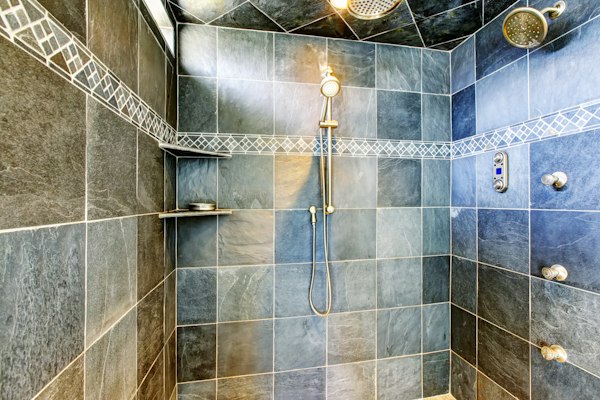 Custom steam shower stall with 12-inch square tiles and digital steam shower control panel.