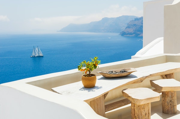 Greek-style Mediterranean balcony overlooking the Mediterranean Sea and a sail boat.