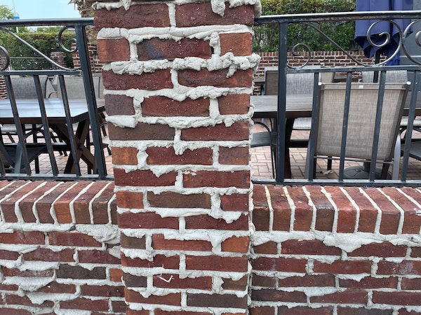Extruded mortar or weeping mortar on a fence outside of a popular restaurant in Myrtle Beach, SC.