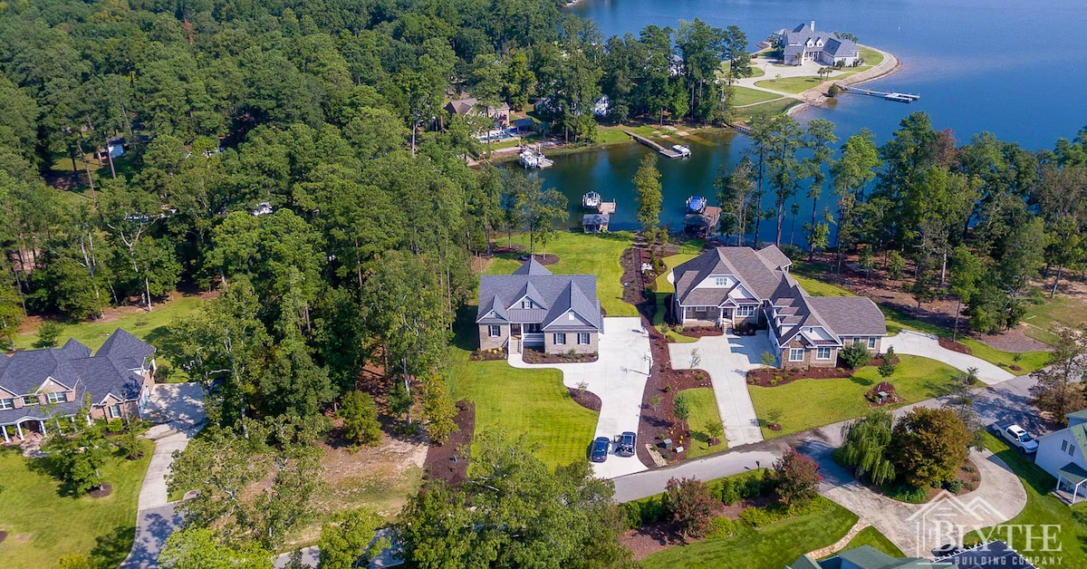 Distant drone shot of a brick Modern Craftsman house on a peninsula on Lake Murray in South Carolina.
