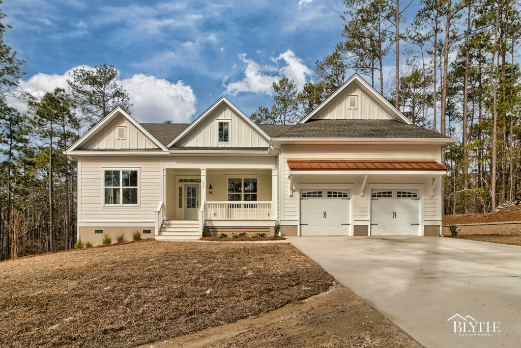 Modern Craftsman home with two carriage garage doors, a copper roof accent over the garage, 3 gables, board and batten gable accents, Hardie board plank siding, and a small front porch and single front entry.