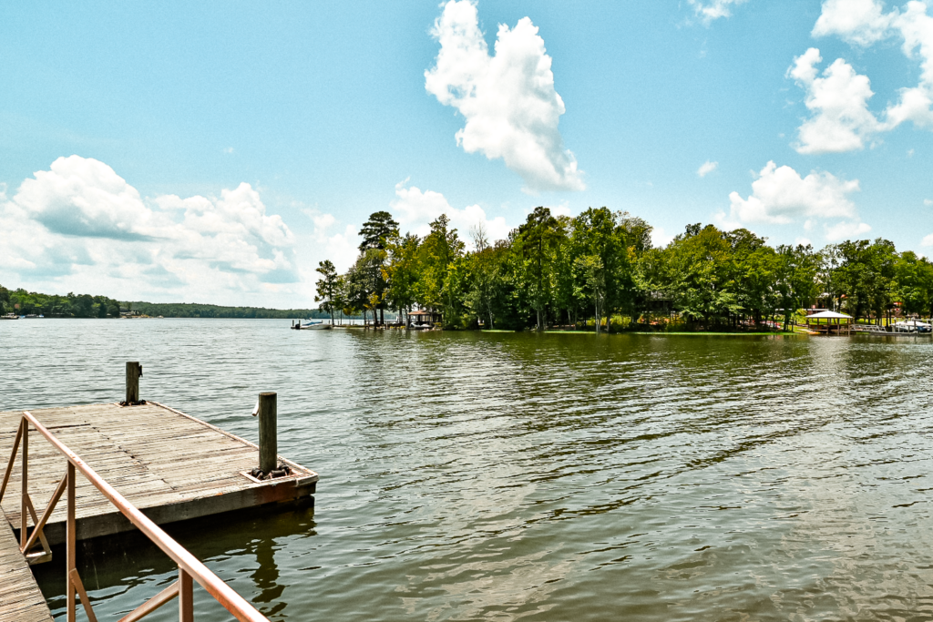 View of Lake Murray from a dock in WhiteWater Landing on a sunny day with blue sky and white clouds.